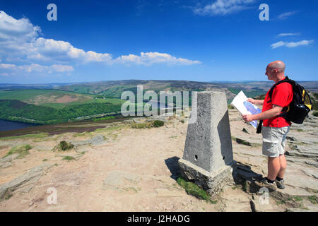 Walker, OS Trig punto su Win Hill su serbatoio Ladybower, Derwent Valley, nel Derbyshire, Parco Nazionale di Peak District, England, Regno Unito Foto Stock