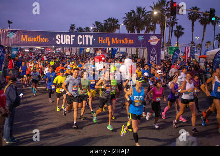 Multirazziale prima maratona-calore concorrenti di lasciare la linea di partenza di prima mattina in Huntington Beach, CA, colloquialmente noto come 'Surf città". Foto Stock