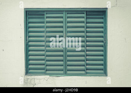 Vecchia finestra verde isolato su un muro rotto. Finestra Farm (Azienda). Foto Stock