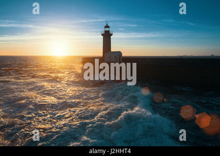 Ocean surf sulla costa atlantica, vicino al faro durante un bel tramonto, Porto, Portogallo. Foto Stock