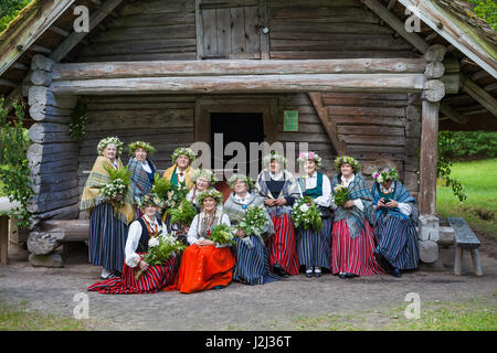 RIGA, Lettonia - 12 GIU 2016: gruppo di donne in nazionale lettone costumi in posa vicino alla vecchia casa in legno. Aria aperta lettone museo etnografico. Foto Stock