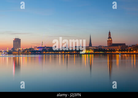 Old Riga dello skyline di notte. Città illuminata dopo il tramonto. Vista panoramica sul fiume Daugava Foto Stock