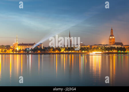 Old Riga dello skyline di notte. Città illuminata dopo il tramonto. Vista panoramica sul fiume Daugava Foto Stock