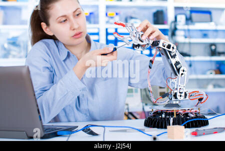 Ingegnere di sesso femminile che lavora in un laboratorio di robotica. Foto Stock