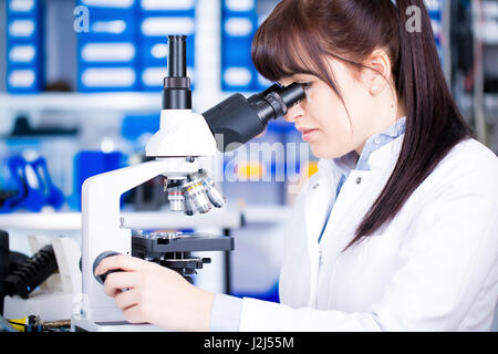 Femmina Studente medico usando microscopio. Foto Stock