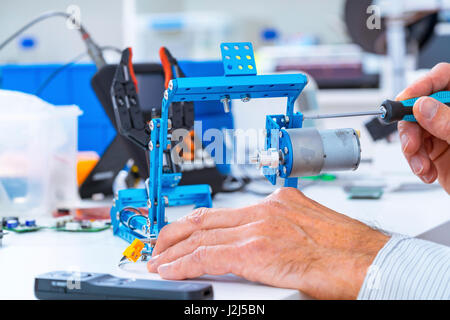 Persona che lavora con componenti robotici. Foto Stock