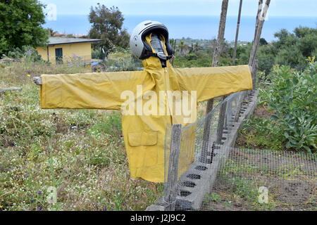 Stravagante spaventapasseri realizzato con un casco e impermeabile Foto Stock