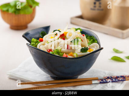 Udon, Giapponese Tagliatelle con verdure in una ceramica artigianale ciotola. Foto Stock