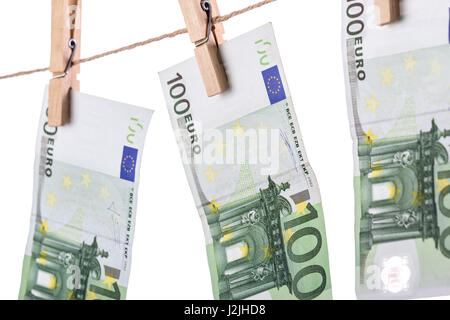 100 banconote in euro appesi stendibiancheria su sfondo bianco. Riciclaggio di denaro del concetto. Primo piano Foto Stock