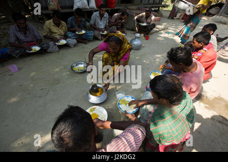 Gli allevatori con pasto sul cortile vicino a la patata archiviato. Munshiganj, Bangladesh. Foto Stock