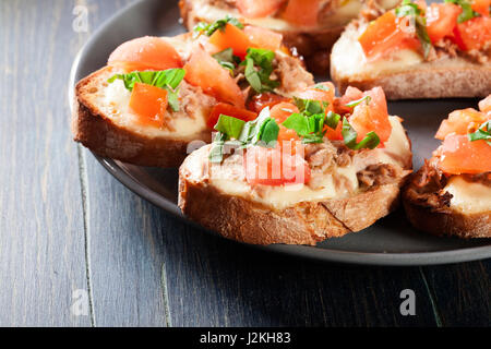 Antipasto bruschetta con tonno, mozzarella e pomodoro. Cucina italiana Foto Stock