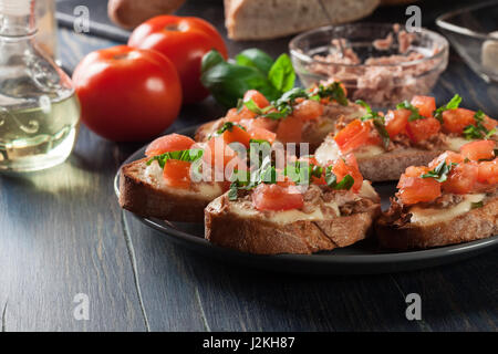 Antipasto bruschetta con tonno, mozzarella e pomodoro. Cucina italiana Foto Stock