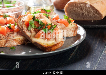 Antipasto bruschetta con tonno, mozzarella e pomodoro. Cucina italiana Foto Stock