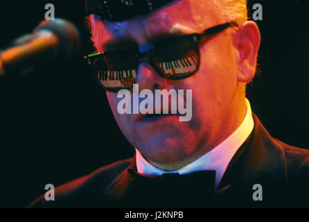 Elton John in concerto con la tastiera si riflette nei suoi occhiali Foto Stock