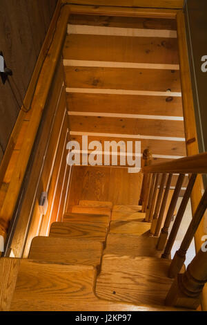 Vista superiore della disomogeneità di scale in legno che conduce al pianterreno piano all'interno di un Canadiana cottage in stile casa di log. Foto Stock