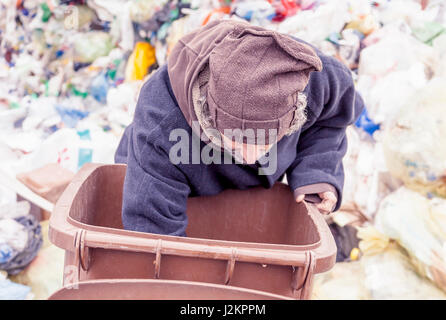 Senzatetto rummages nella pattumiera di discariche Foto Stock