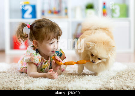 Carino bambina e divertente cane a casa Foto Stock