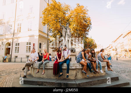 Affettuosa coppia giovane seduto sul vecchio vintage fontana a Lviv city centre Foto Stock