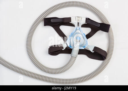 Apnea nel sonno CPAP mask e il tubo flessibile sul cuscino bianco sfondo, per l'uso con CPAP macchina per persone con apnea nel sonno o disturbi del sonno Foto Stock