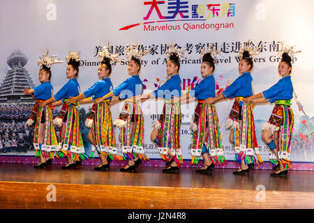 Kaili, Guizhou, Cina. Dong etnica esecutori accogliendo turisti stranieri di Qiandongnan provincia. Foto Stock