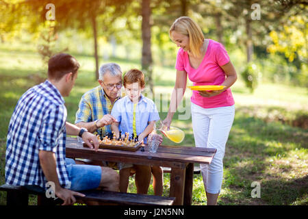 Family break da una partita a scacchi in posizione di parcheggio Foto Stock