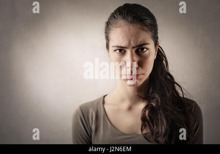 Brunette donna che fa il Viso arrabbiato Foto Stock