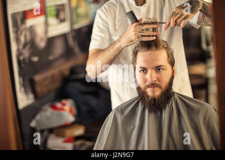 Taglio di capelli da un parrucchiere professionista con le forbici Foto Stock