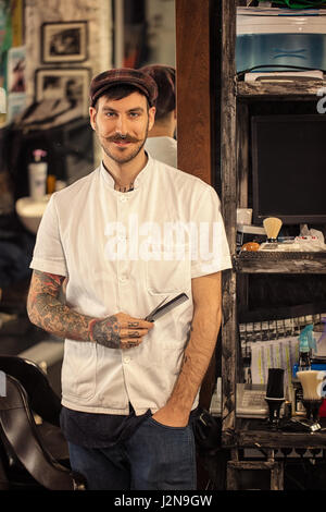 Sorridente ritratto di hipster permanente Barber shop interni Foto Stock