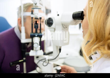 Ottica femmina di riesaminare gli occhi con apparecchiatura Foto Stock