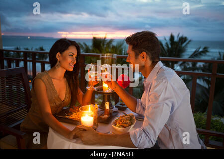 Coppia giovane godendo di una cena romantica a lume di candela, per esterno Foto Stock