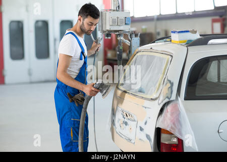 Lavoratore preparare parte del corpo per la verniciatura Foto Stock