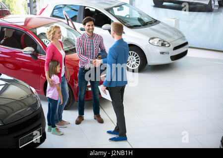 Venditore auto che mostrano un nuovo veicolo per la famiglia, i clienti Foto Stock