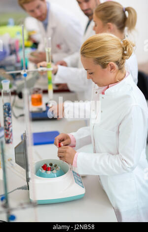 Femmina tecnici lavorano con preparazione di provette per shaker in laboratorio Foto Stock
