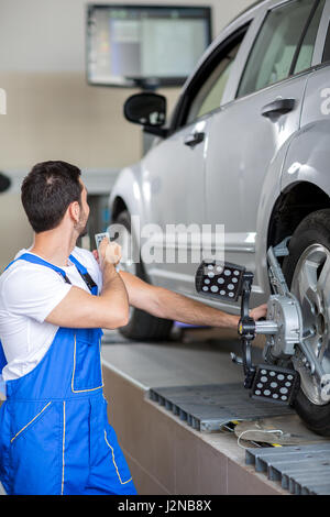 Auto con sensori sulle ruote sul controllo in officina di servizio Foto Stock