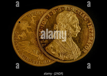 Vista ravvicinata di due su un altro Austria-ungheria thalers, avers e revers di golden coin-ducati dal 1915 con Kaiser Franz Joseph I, sul retro scuro Foto Stock