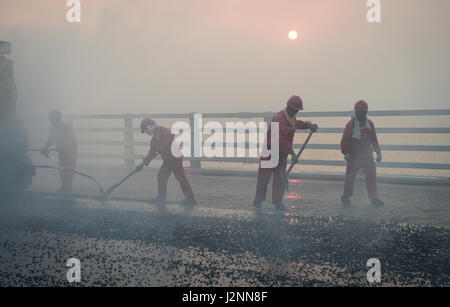 Zhuhai, la Cina della provincia di Guangdong. 29 apr, 2017. Costruttori utilizzare asfalto alla superficie di Hong Kong-Zhuhai-ponte di Macao a Zhuhai Cina del sud della provincia di Guangdong, Aprile 29, 2017. Credito: Liu Dawei/Xinhua/Alamy Live News Foto Stock