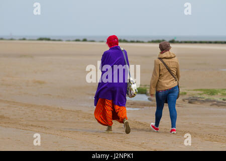 New Brighton, Wallasey, Regno Unito. Regno Unito Meteo. Il 30 aprile, 2017. Soleggiato con venti gusty nel resort e luce sabbia windborne provocando irritazione ai turisti che si godono la passeggiata sulla spiaggia in acque basse. Credito; MediaWorldImages/AlamyLiveNews Foto Stock