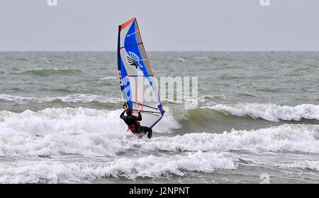 Brighton Regno Unito 30 aprile 2017 - un windsurf rende la maggior parte delle condizioni di ariosi off Hove beach oggi .Le previsioni meteo per il weekend è impostata per una miscela di sole e docce nel sud del Regno Unito Foto Stock