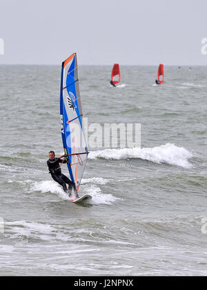 Brighton Regno Unito 30 aprile 2017 - un windsurf rende la maggior parte delle condizioni di ariosi off Hove beach oggi .Le previsioni meteo per il weekend è impostata per una miscela di sole e docce nel sud del Regno Unito Foto Stock