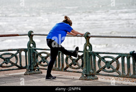 Brighton Regno Unito 30 aprile 2017 - un runner si estende sul lungomare Hove oggi .Le previsioni meteo per il weekend è impostata per una miscela di sole e docce nel sud del Regno Unito fotografia scattata da Simon Dack Foto Stock