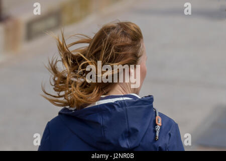 New Brighton, Wallasey, Regno Unito. Regno Unito Meteo. Il 30 aprile, 2017. Soleggiato con venti gusty nel resort e luce sabbia windborne provocando irritazione ai turisti che si godono la passeggiata sulla spiaggia in acque basse. Credito; MediaWorldImages/AlamyLiveNews Foto Stock