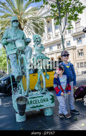 Una giovane coppia di brodi posano con una strada attore vestito come un ciclista sulla Rambla di Barcellona. Foto Stock