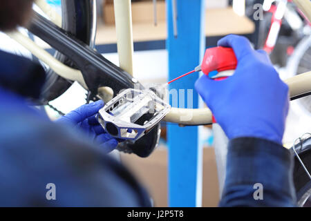 La lubrificazione del pedale in moto. Bike, di riparazione e di manutenzione. Accessori per biciclette, la preparazione di una bici da corsa. Il servizio bici, manutenzione del pedale. Foto Stock