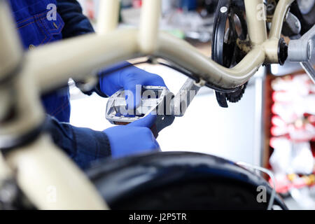 La lubrificazione del pedale in moto. Bike, di riparazione e di manutenzione. Accessori per biciclette, la preparazione di una bici da corsa. Il servizio bici, manutenzione del pedale. Foto Stock