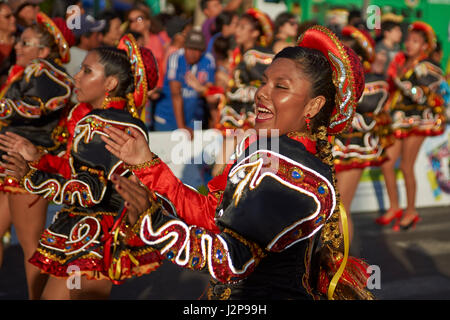 Elementi femmina di un Caporales il gruppo di musica da ballo in costumi ornati di eseguire l'annuale Carnaval Andino con la Fuerza del Sol a Arica, Cile. Foto Stock