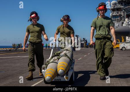 USS MAKIN ISLAND, Oceano Pacifico (14 aprile 2017) DEGLI STATI UNITI Marine ordnance tecnici con mezzo marino Tiltrotor Squadron 163 (rinforzato), undicesimo Marine Expeditionary Unit (MEU), spostare due Mk.82 500 lb Alta bombe esplosive per essere caricata su un AV-8B Harrier come parte di un accordo bilaterale in materia di esercizio di formazione condotte con il malese delle Forze Armate, 14 aprile. Pur essendo distribuito con un MEU, la missione principale di un ordnance tecnico è di mantenere e caricare inesplosi sul velivolo per il supporto di varie missioni. La Makin Island anfibio gruppo pronto/xi MEU attualmente distribuito negli Stati Uniti 7 flotta sono Foto Stock