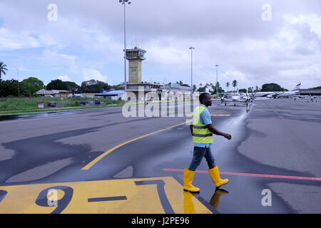 Un operaio cammina sul tarmac di Abeid Amani Karume International Airport l'aeroporto principale nell'arcipelago di Zanzibar situato sull'isola di Unguja a sud di Zanzibar City, la capitale di Zanzibar una parte semi-autonoma della Tanzania, in Africa orientale Foto Stock