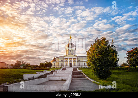 Kolomna chiesa di San Michele Arcangelo con un campanile di alba con belle le nuvole e la luce dorata. Foto Stock