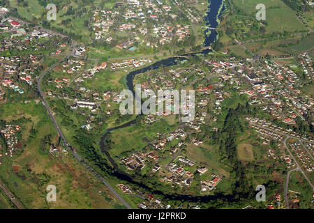 Fotografia aerea di un insediamento urbano circondato da una cintura verde e terreni agricoli. Foto Stock