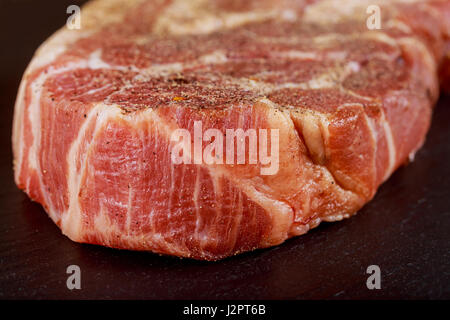 Pezzi di carne fresca con aglio e pepe e prezzemolo tagliere pronto per la cottura Foto Stock